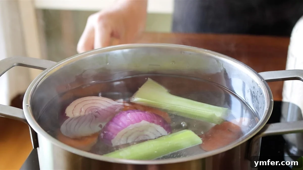 Effortless Plant-Based Risotto 8 Preparing homemade vegetable stock in a pot with fresh vegetables.