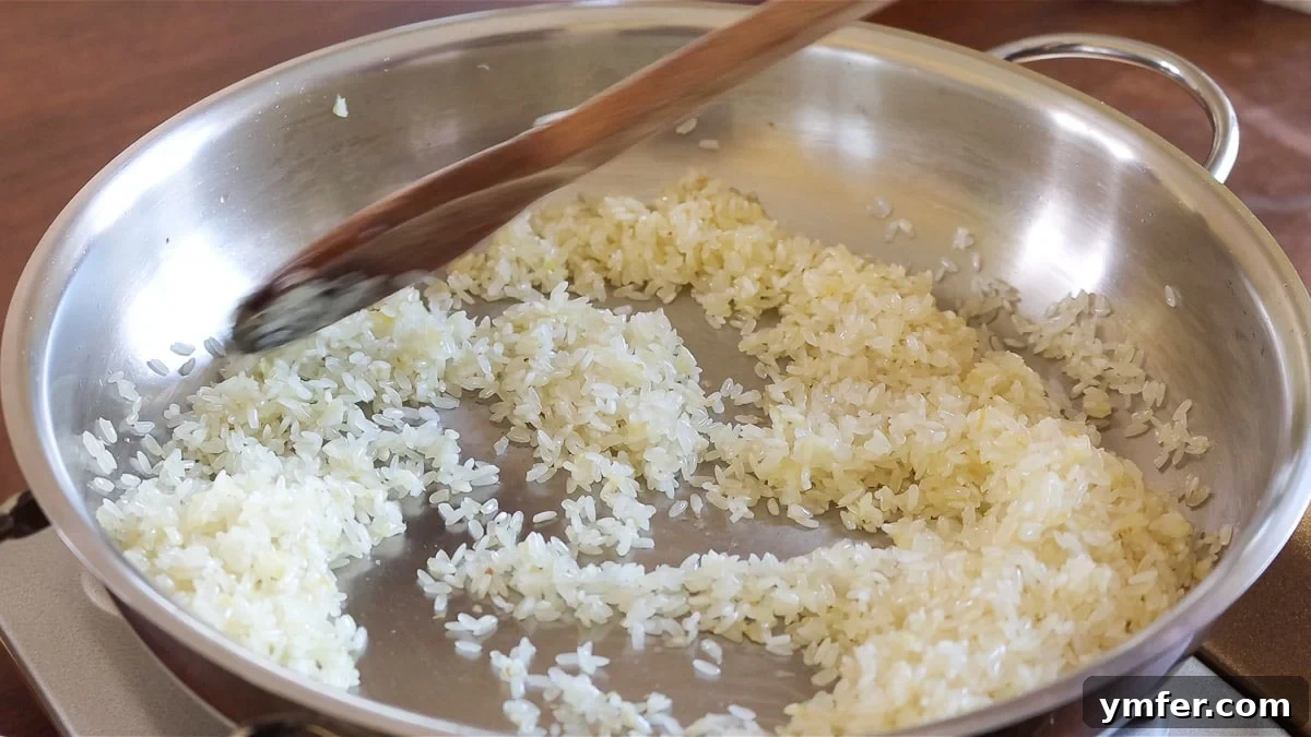 Effortless Plant-Based Risotto 10 Onions and risotto rice being sautéed together in a pot.