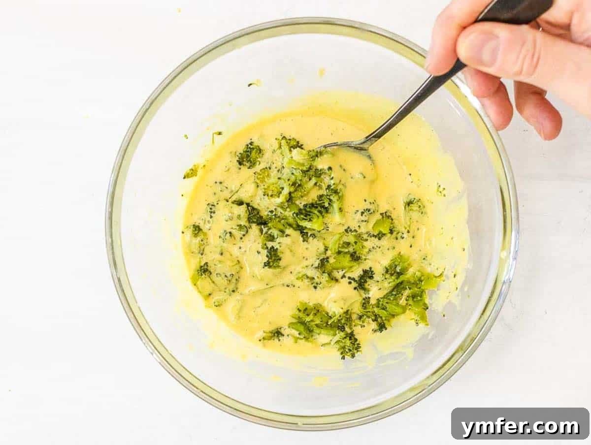 Wholesome Chickpea Egg Muffins 13 Chickpea Muffins with steamed broccoli and hand holding a spoon