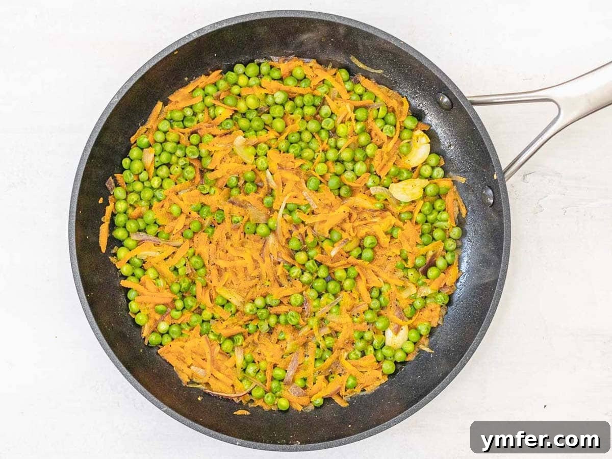 Wholesome Chickpea Egg Muffins 7 black skillet with peas and grated carrots