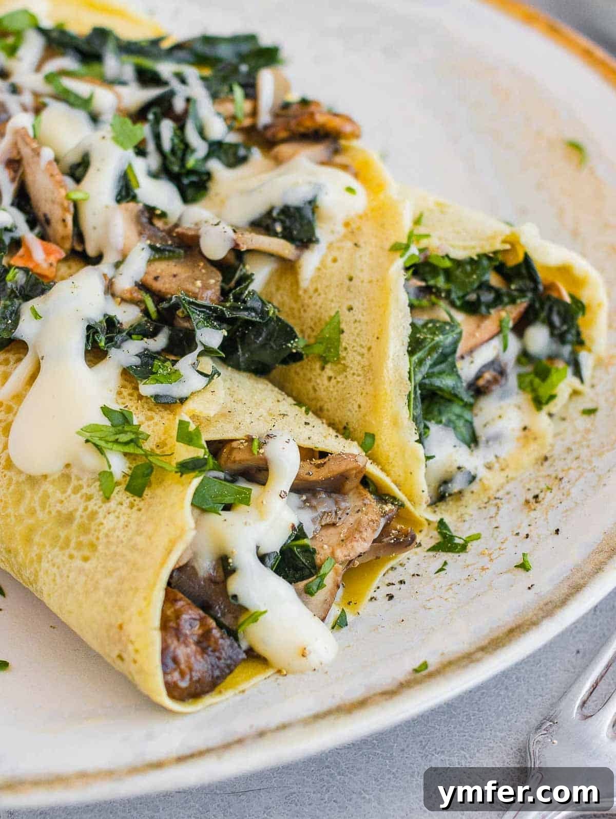 Savory Crepe Delights 2 Delicious savory crepes with creamy white sauce and fresh parsley garnish
