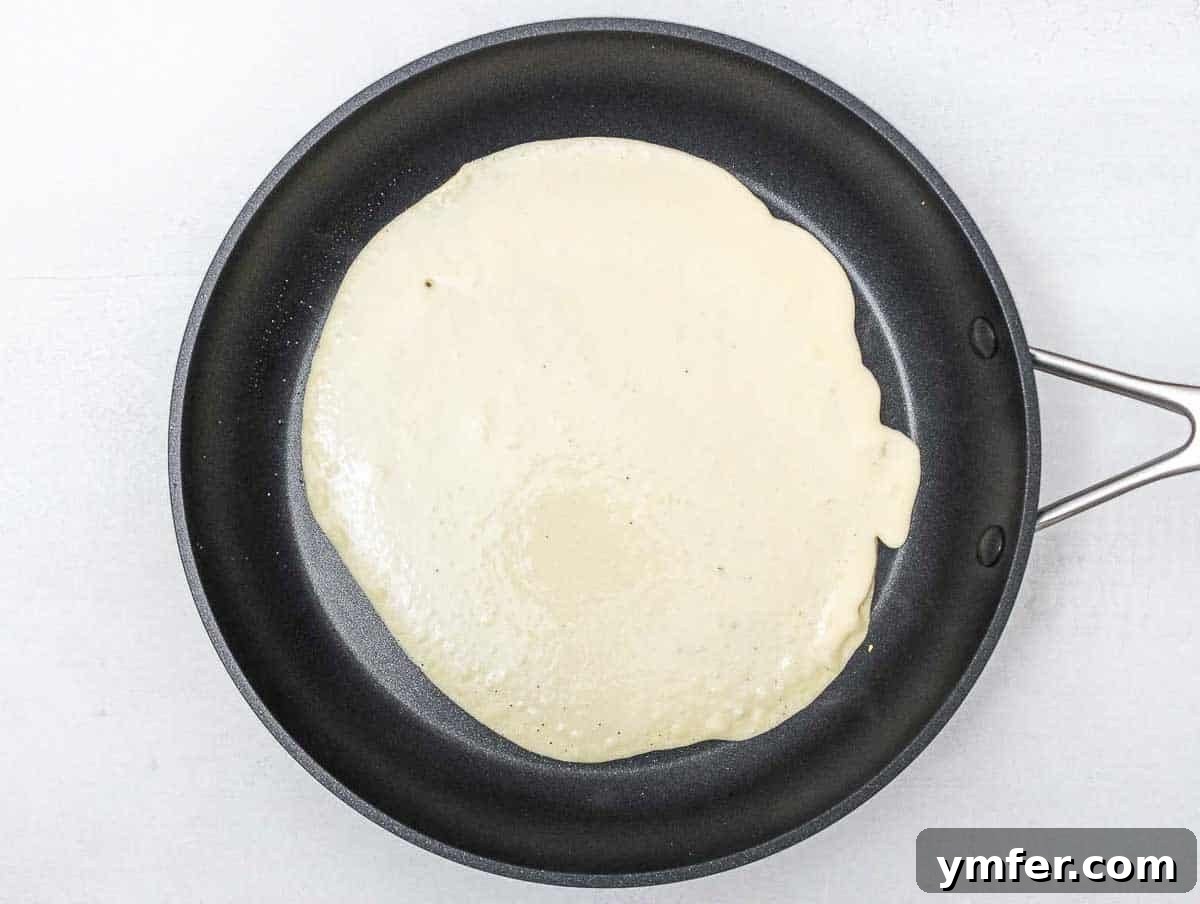 Savory Crepe Delights 11 A savory chickpea crepe cooking to golden perfection in a pan