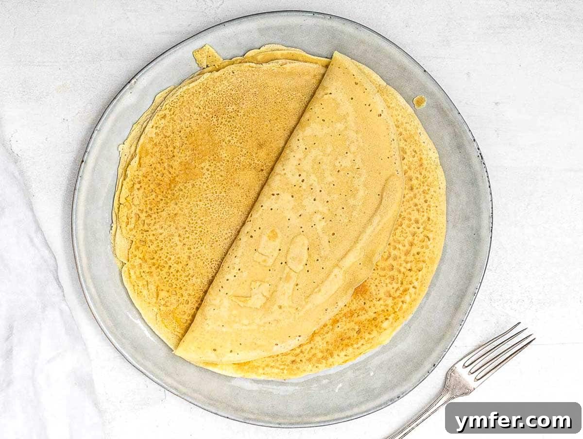 Savory Crepe Delights 12 Stack of freshly cooked savory crepes on a plate