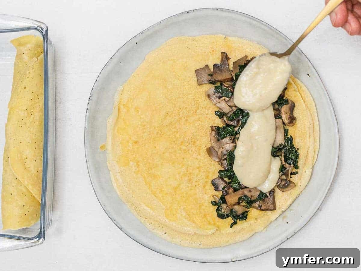 Savory Crepe Delights 13 Spreading white sauce on a savory crepe before filling