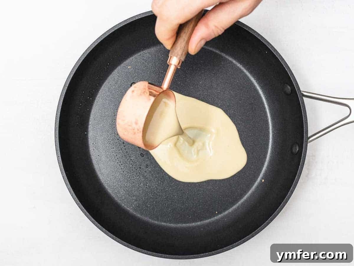 Savory Crepe Delights 10 Pouring chickpea crepe batter onto a hot, oiled non-stick pan
