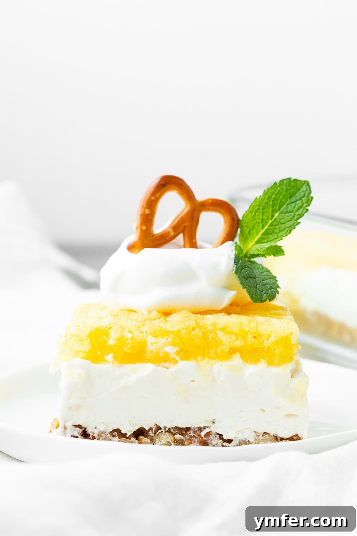 Tropical Pretzel Delight 4 The top view of a Pineapple Pretzel Salad showing the smooth, golden pineapple jello layer covering the creamy white middle layer.