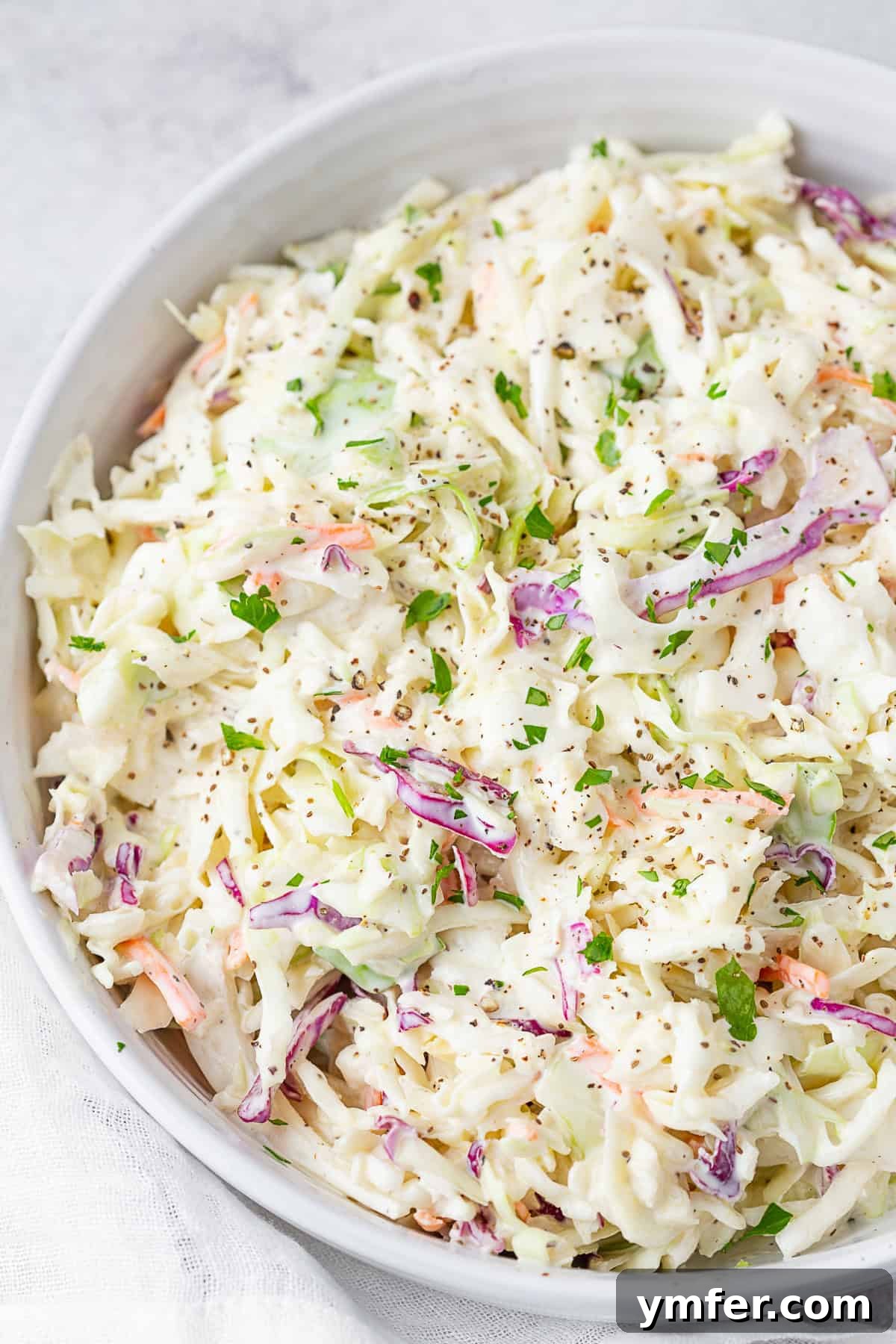 Velvet Cabbage Slaw 5 Creamy Coleslaw in a white serving bowl.