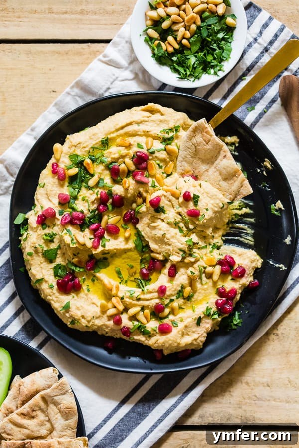 Tahini Free Hummus on a plate with pita bread, ready for dipping. A healthy and flavorful snack or appetizer.