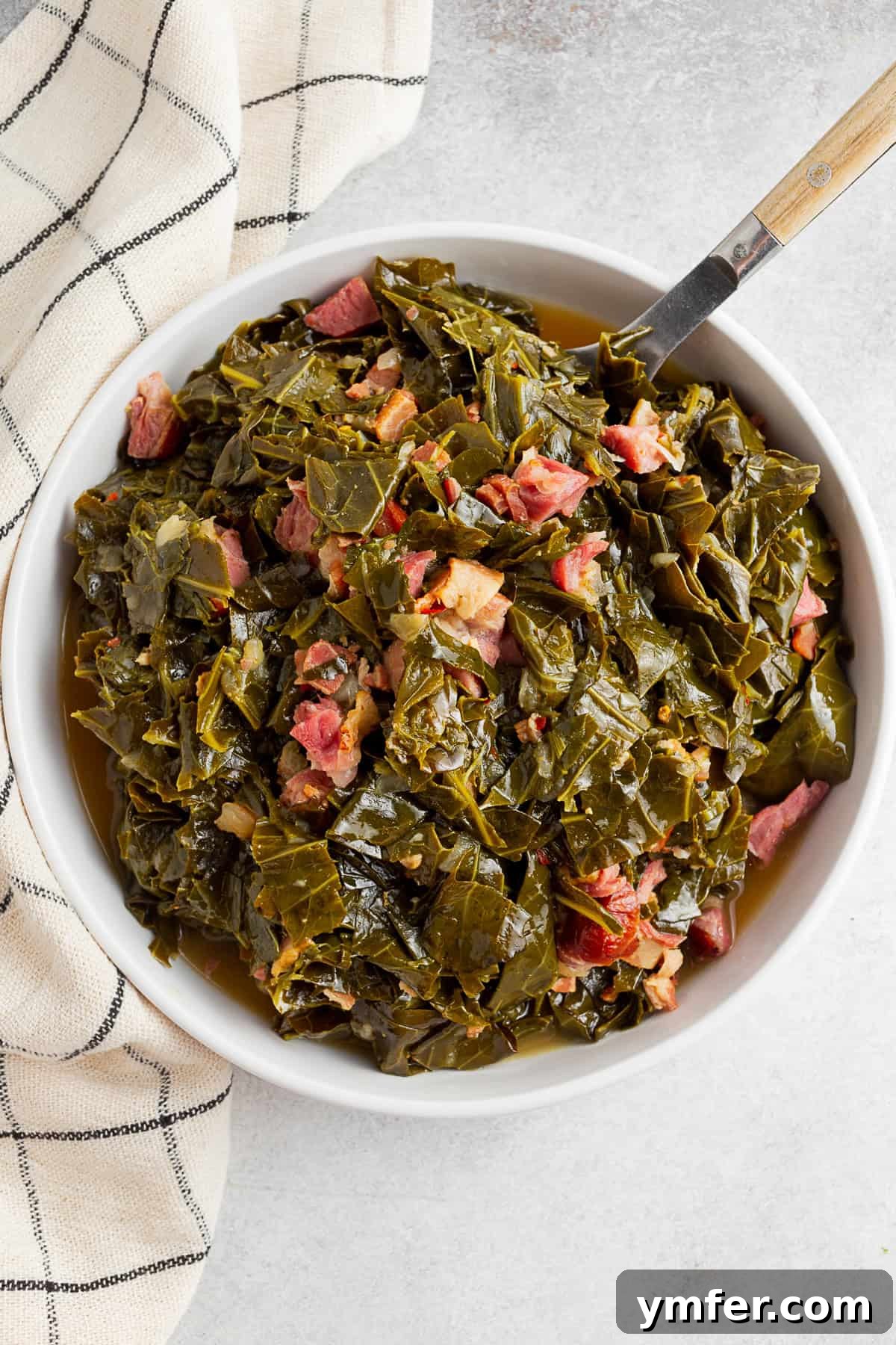 Flavorful Instant Pot Collard Greens 5 Instant Pot Collard Greens on a table with a wooden spoon and napkin.