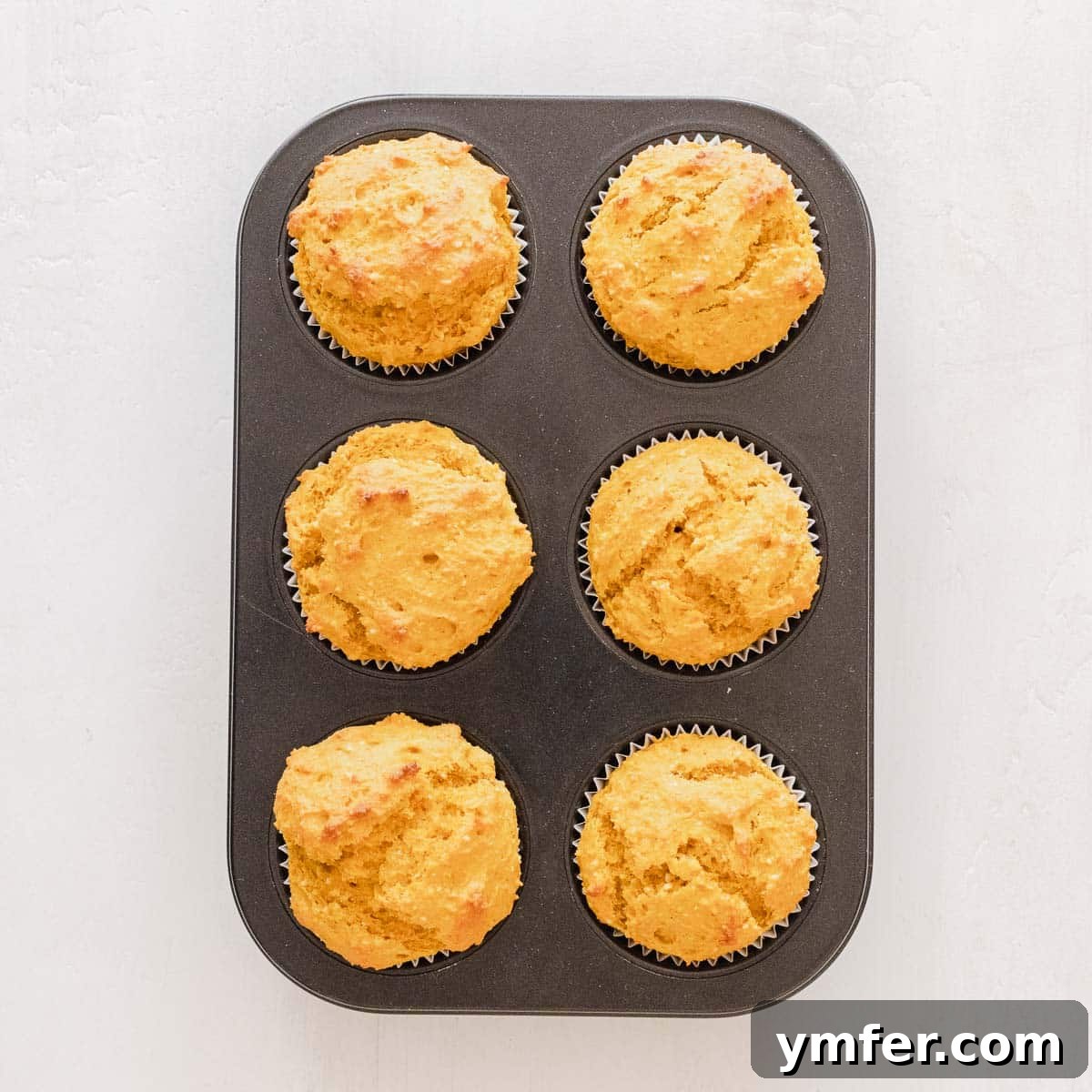 Dolce Carota Cake 16 Muffin pan filled with carrot cake batter and paper liners, ready for baking.