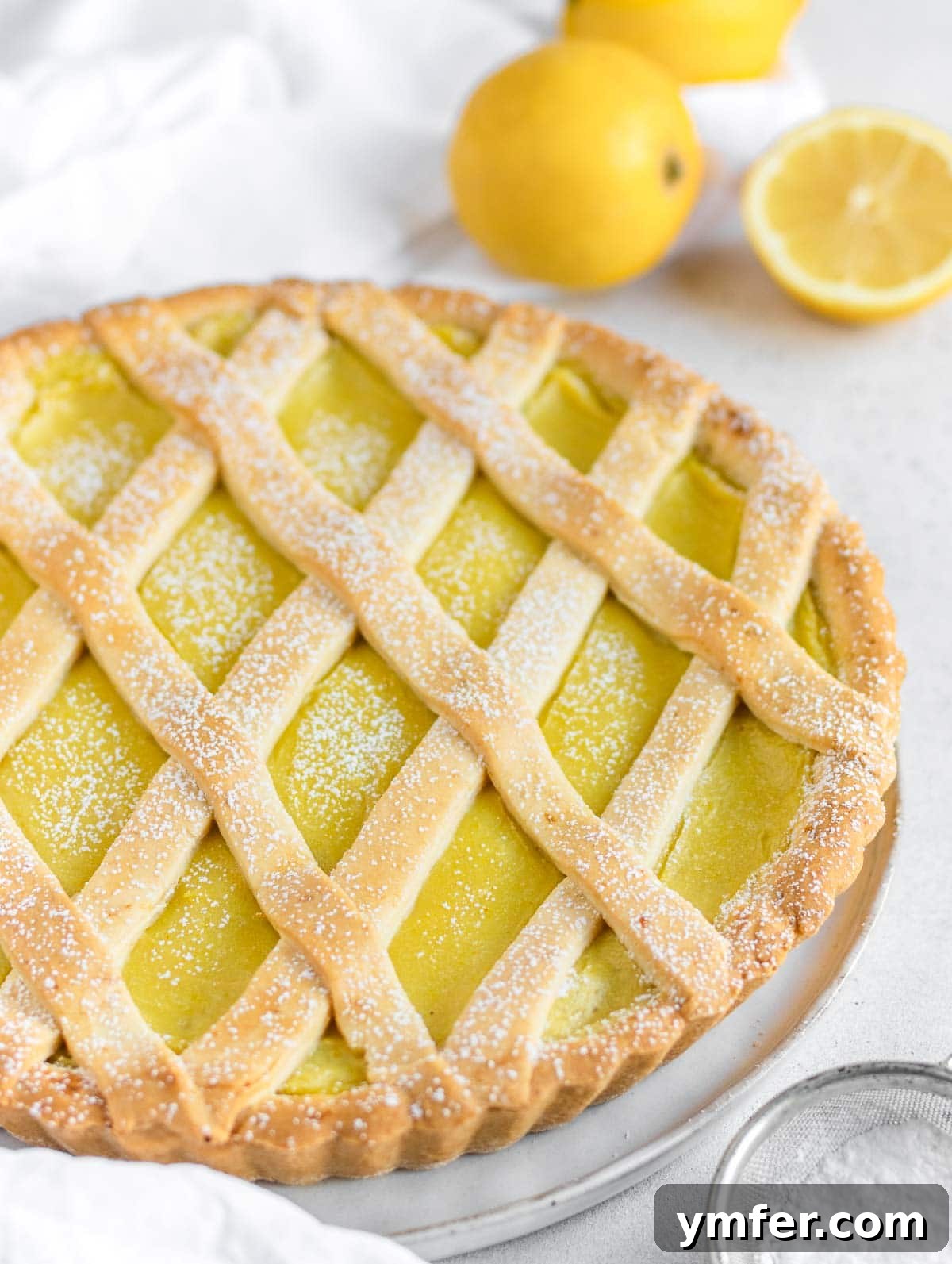 Zesty Plant-Based Lemon Squares 21 A rustic vegan lemon tart (crostata) with a soft, inviting crust, garnished with fresh mint.