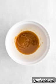 Melted butter and brown sugar being whisked in a bowl.