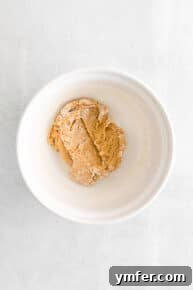 Flour and baking soda being mixed into the cookie dough.