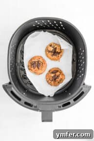 Freshly baked air fryer chocolate chip cookies on a cooling rack.