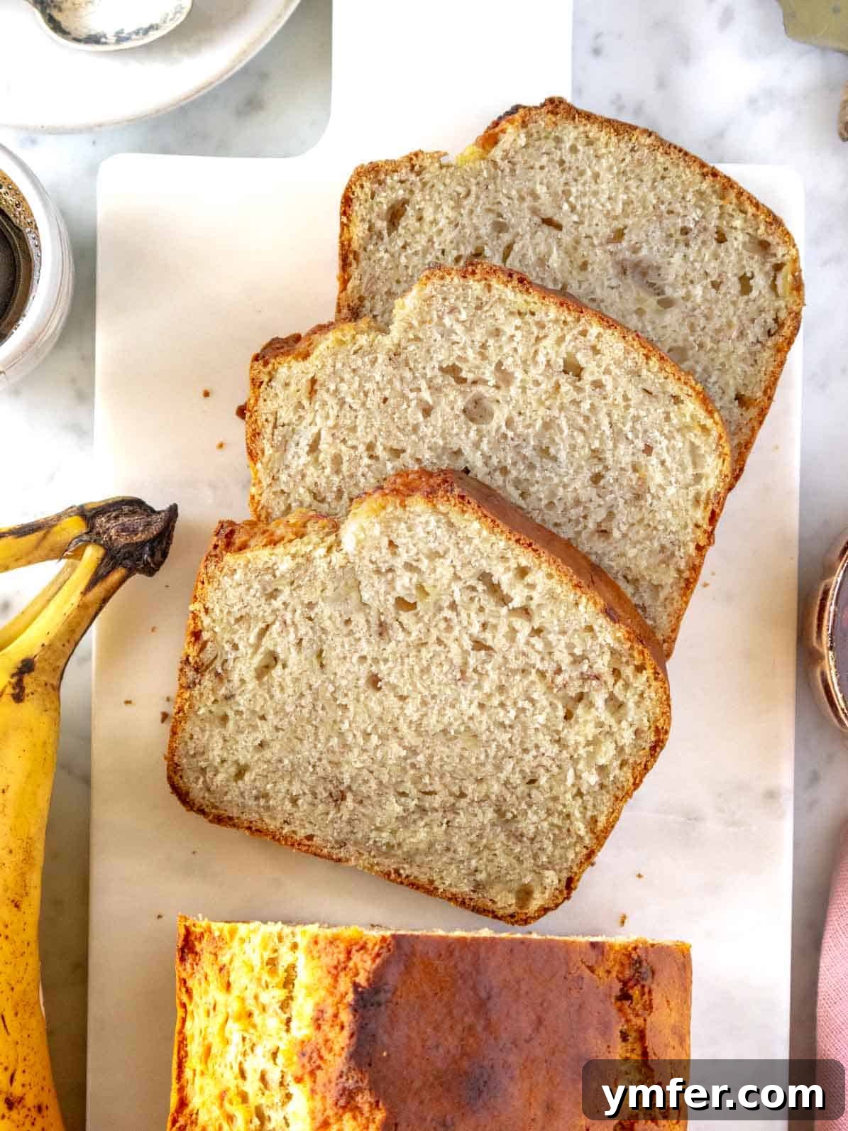 Plant-Powered Banana Bread Perfection 2 Three slices of moist vegan banana bread on a wooden cutting board