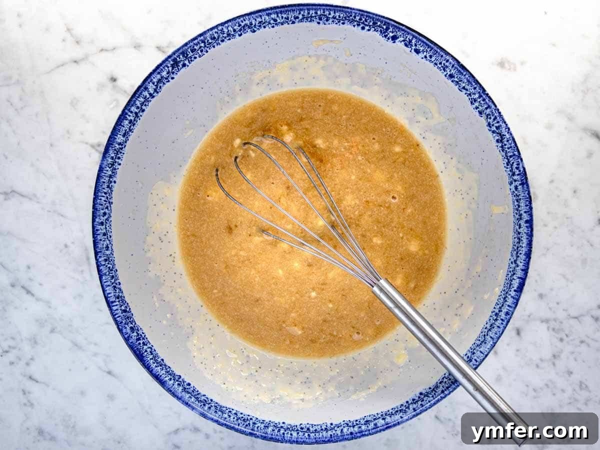 Plant-Powered Banana Bread Perfection 5 Mashed bananas mixed with wet ingredients in a bowl