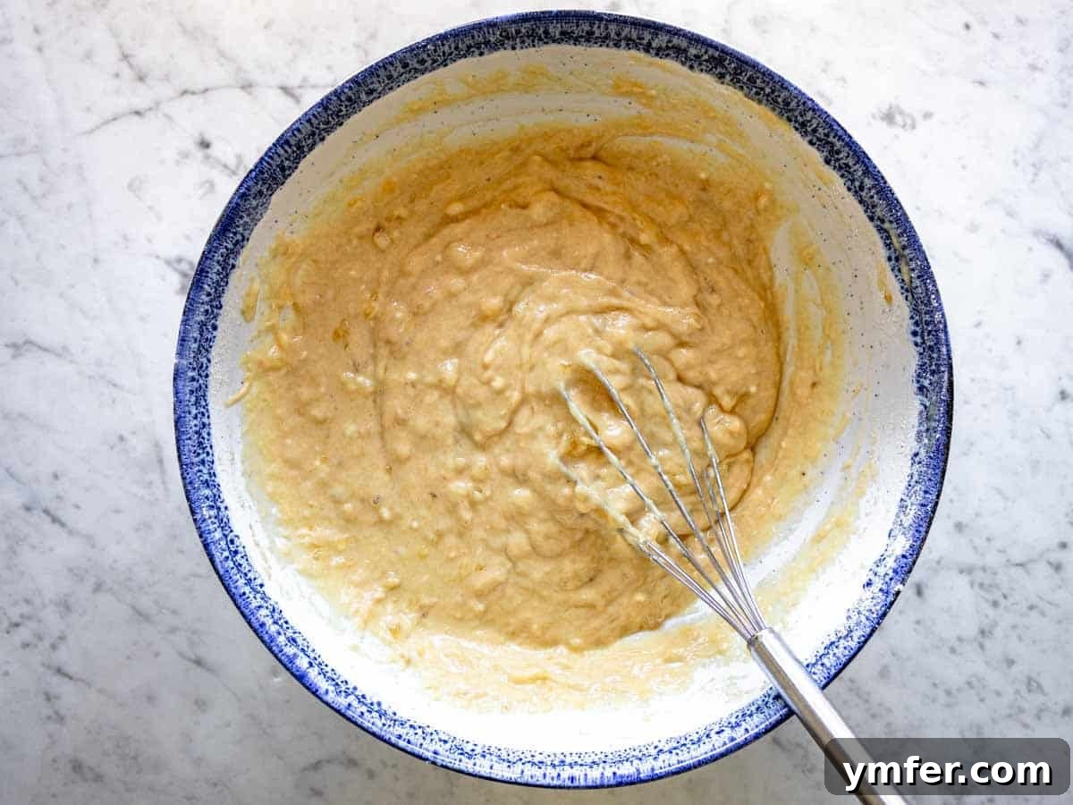 Plant-Powered Banana Bread Perfection 6 Dry ingredients added to wet ingredients in a mixing bowl, ready to be combined