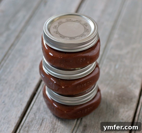 Slow Cooker Homemade Ketchup via Nutmeg Nanny Slow Cooker Homemade Ketchup jars stacked on top of each other.