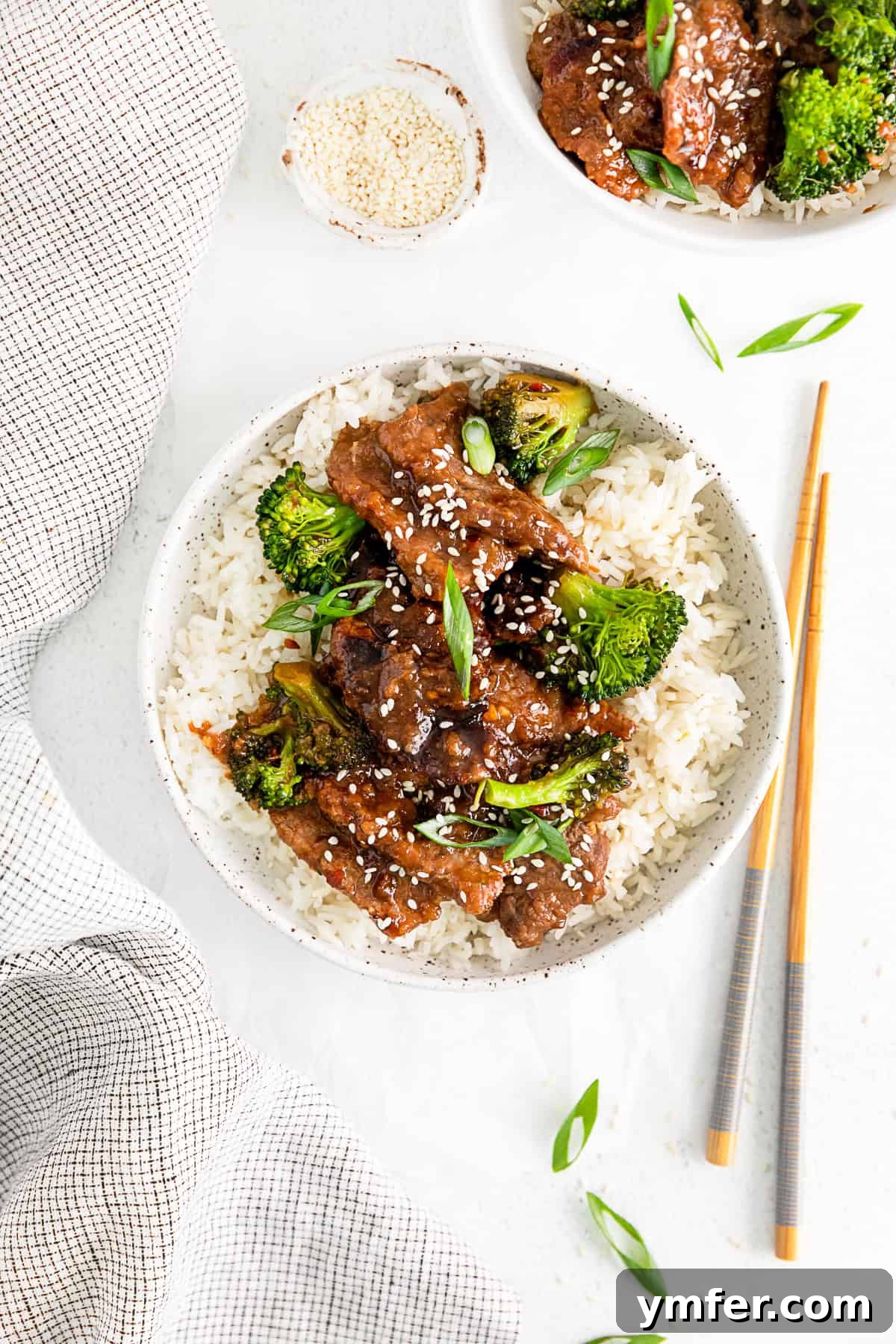 Speedy Instant Pot Mongolian Beef 2 Instant Pot Mongolian Beef in a ceramic bowl served over rice with broccoli, green onions, and sesame seeds.