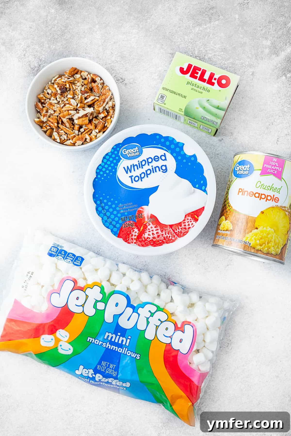 Emerald Pineapple Dream 3 Individual ingredients for Watergate Salad laid out: marshmallows, pineapple, cool whip, pecans, and pudding mix.