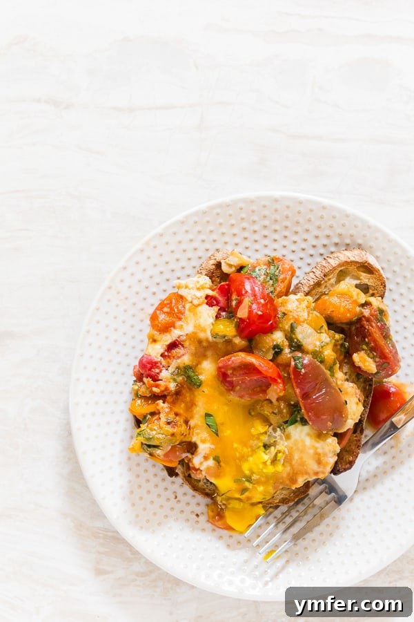 Rustic Bruschetta Egg Bake 4 Bruschetta Baked Eggs in a skillet, ready to be served, garnished with fresh herbs.