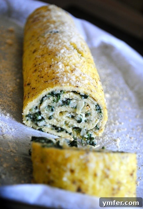 Swirled Spinach Artichoke Egg Roll 3 Spinach Artichoke Egg Roulade, elegantly sliced into individual portions, displayed on a baking sheet pan.