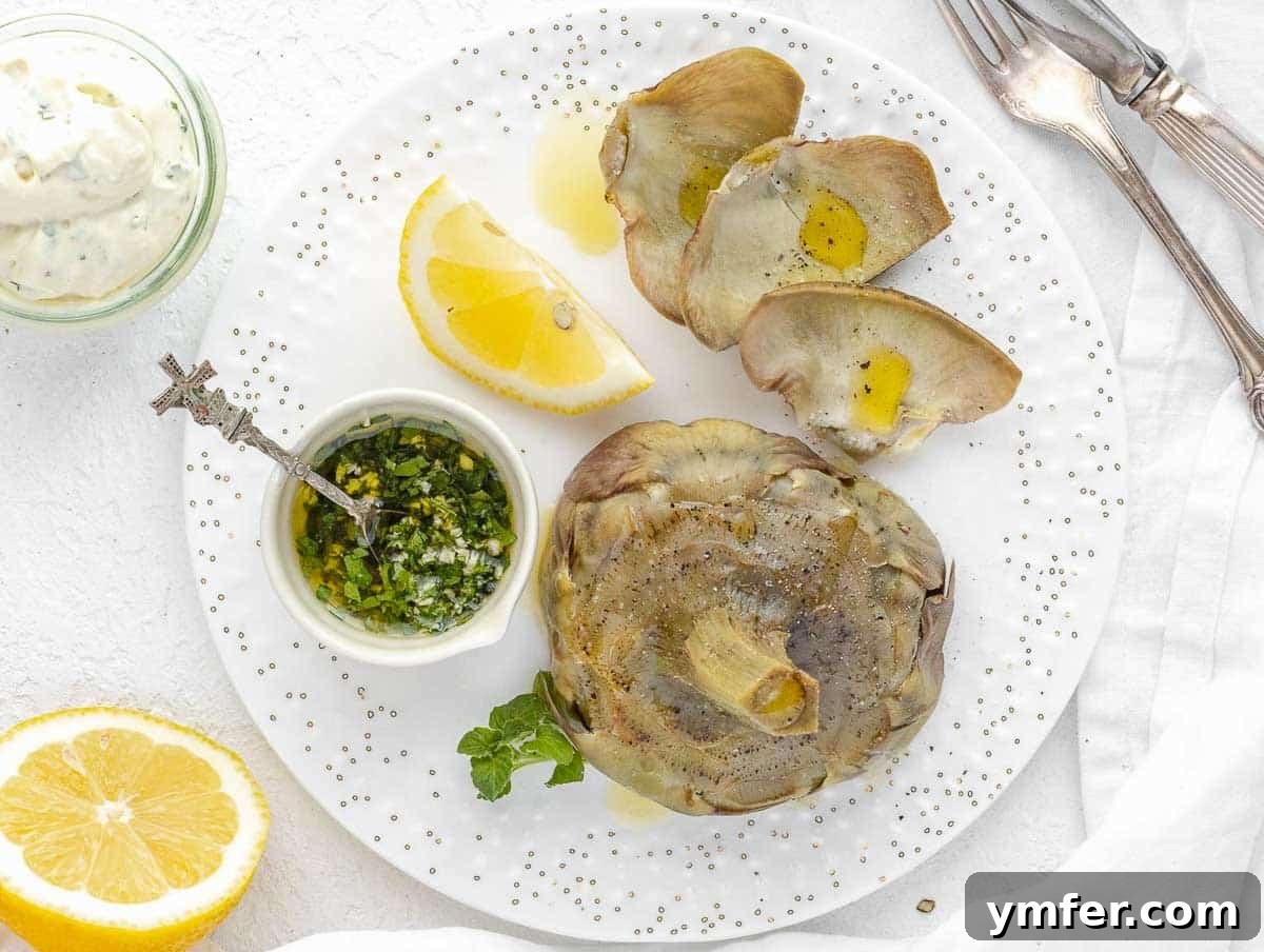 Steamed artichokes arranged on a platter, garnished with fresh herbs and served with a vibrant chimichurri dipping sauce.