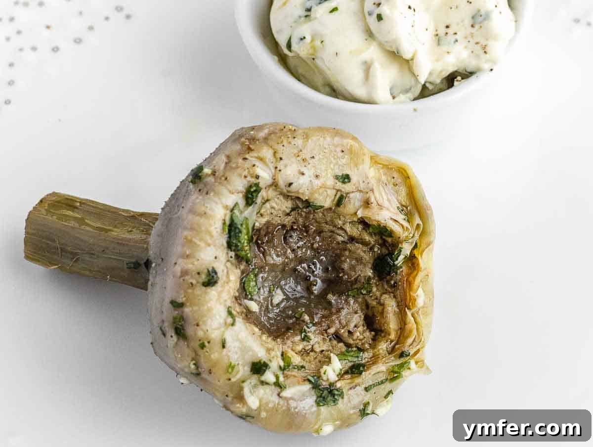 The tender heart of an artichoke with vegan mayonnaise, showcasing its delicious edible core.