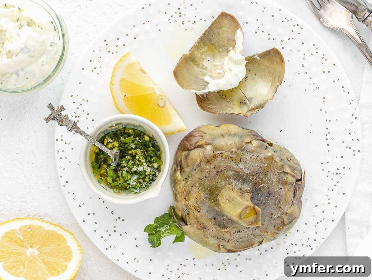 Steamed artichokes dipped in creamy vegan mayonnaise, highlighting their tender petals.