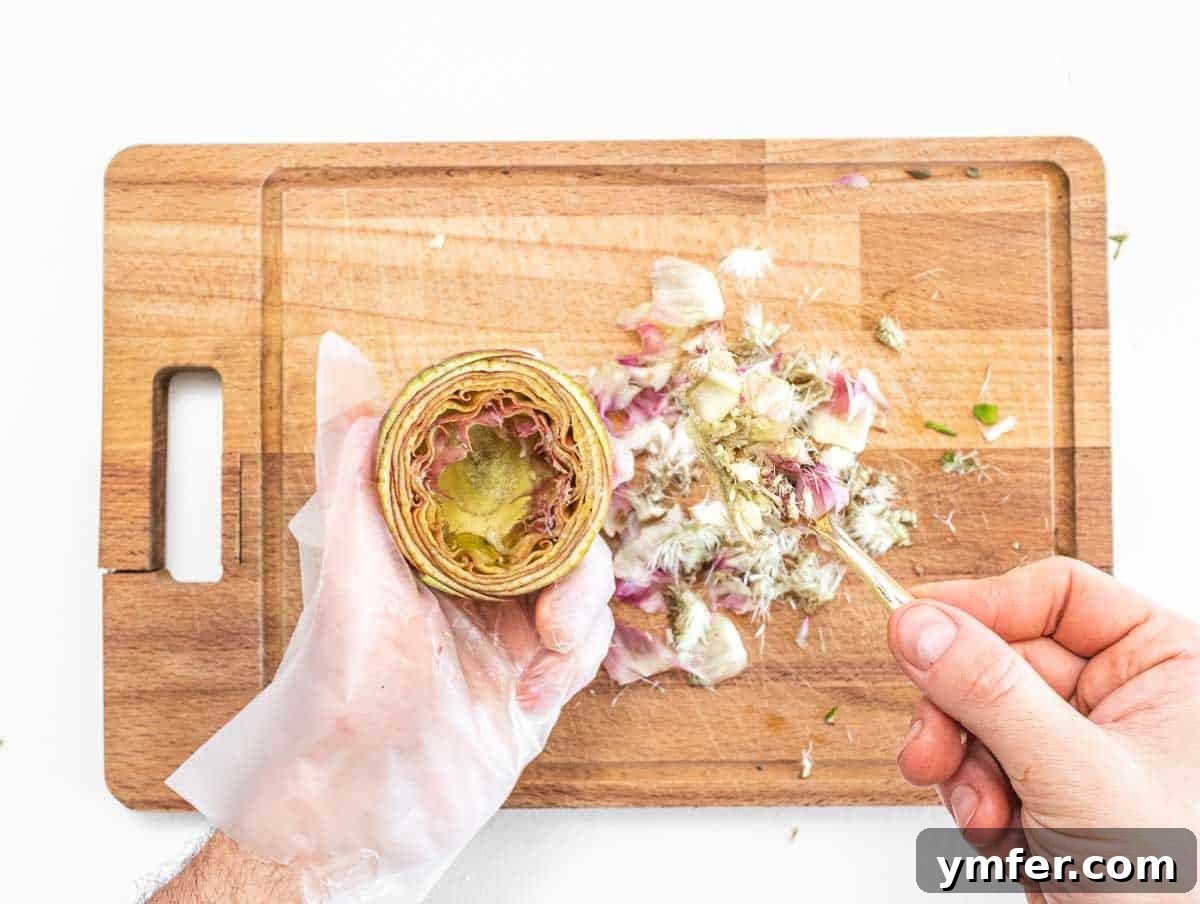 Rome's Signature Artichokes 10 Removing the fuzzy core part of an artichoke with a spoon