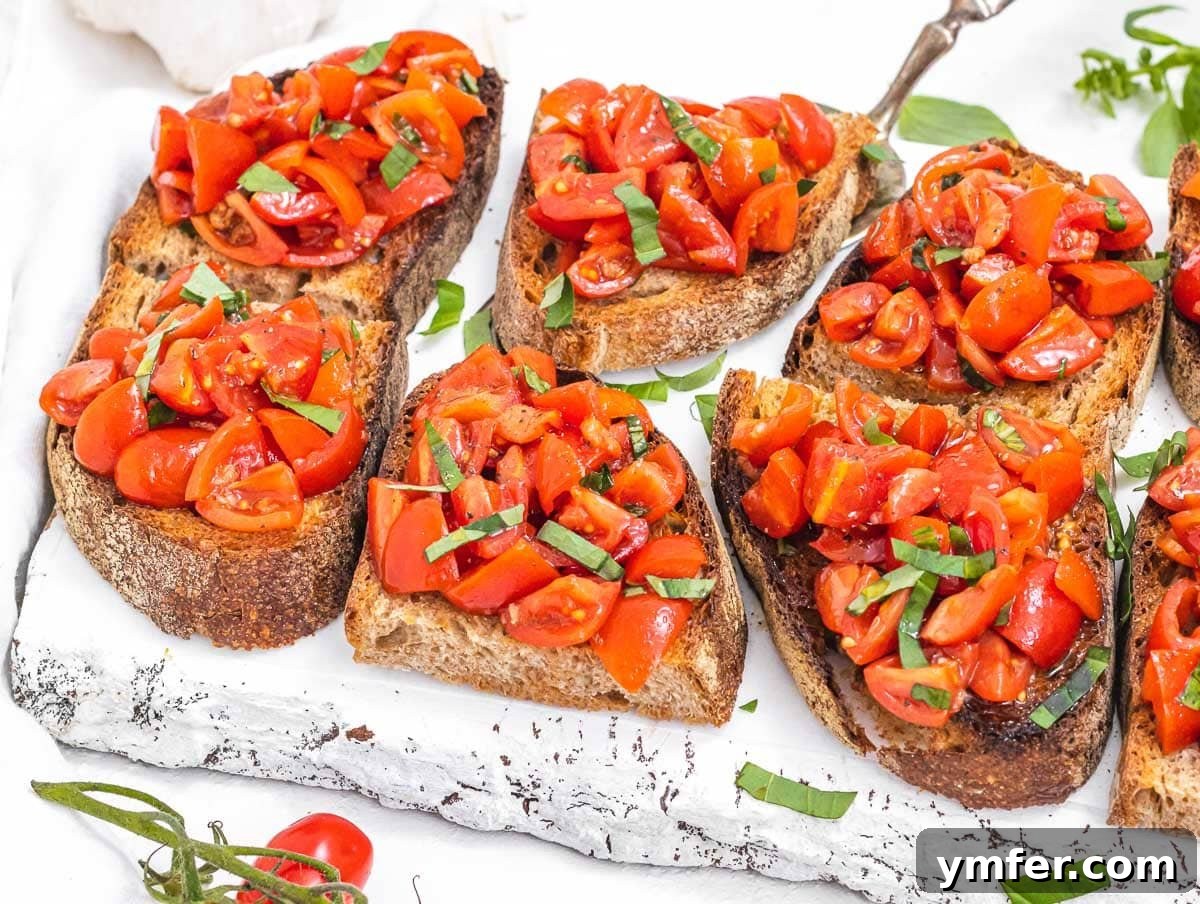 30 Crowd-Pleasing Vegan Starters 20 Classic tomato bruschetta artfully arranged on a white cutting board.