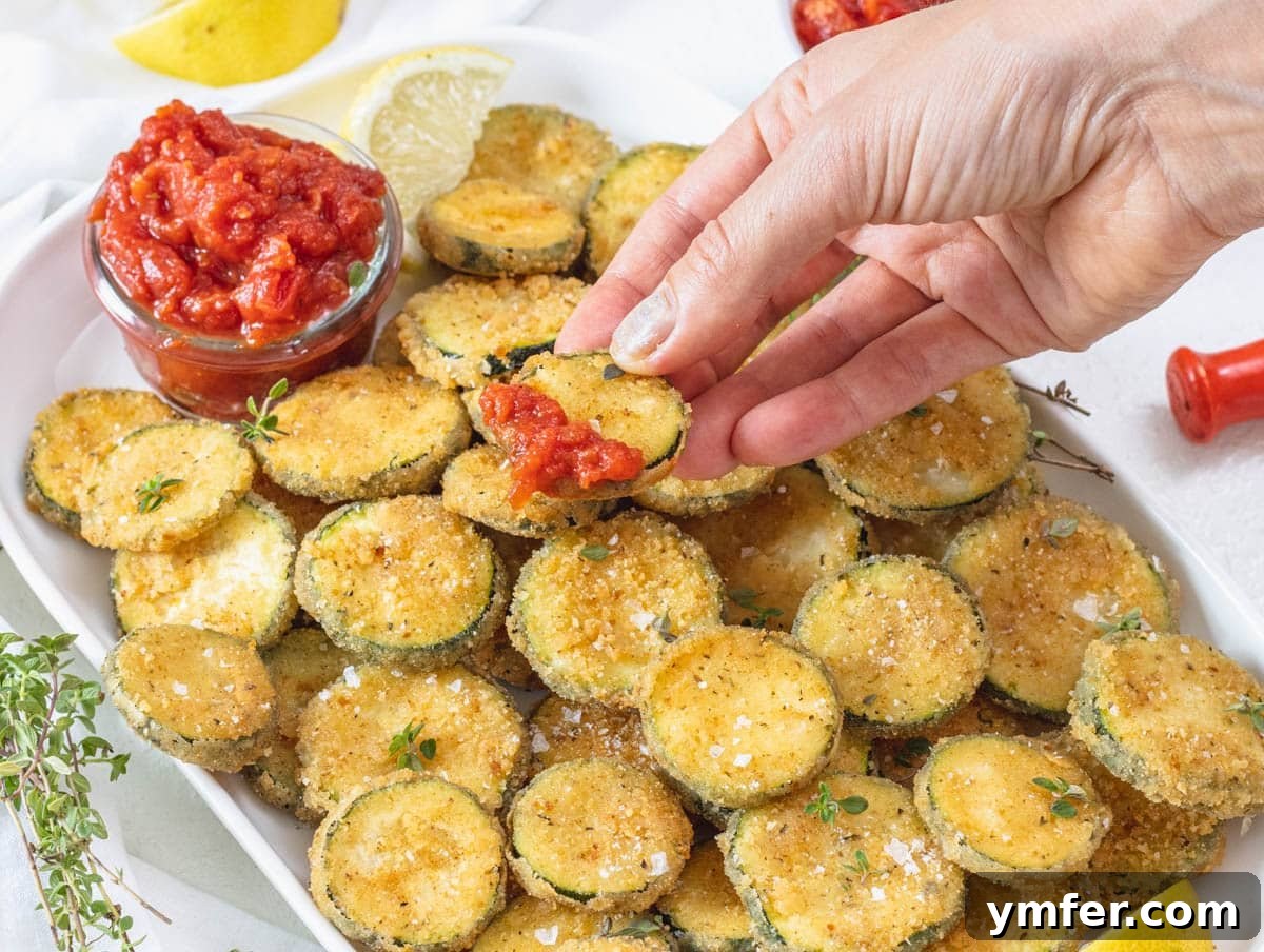 30 Crowd-Pleasing Vegan Starters 22 Crispy fried zucchini being dipped into a rich marinara sauce.