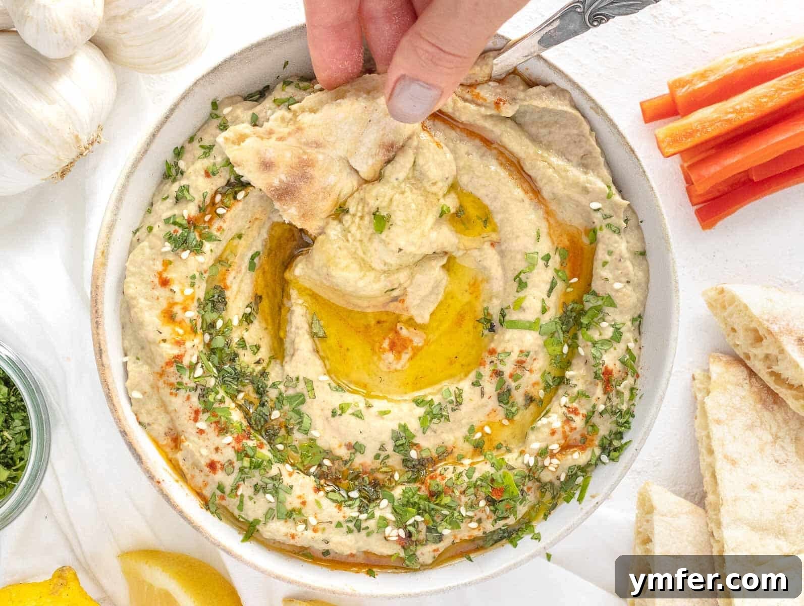 30 Crowd-Pleasing Vegan Starters 8 Pita bread being dipped into a creamy, flavorful eggplant dip (Baba Ganoush).