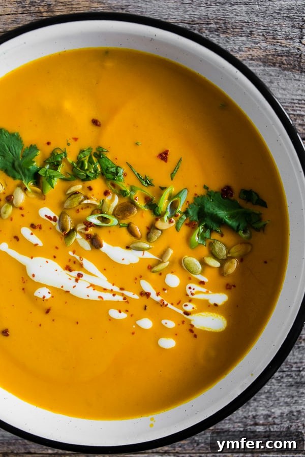 Thai Pumpkin Spice Soup 2 Spicy Thai Pumpkin Soup in a bowl, garnished with fresh herbs and pumpkin seeds.