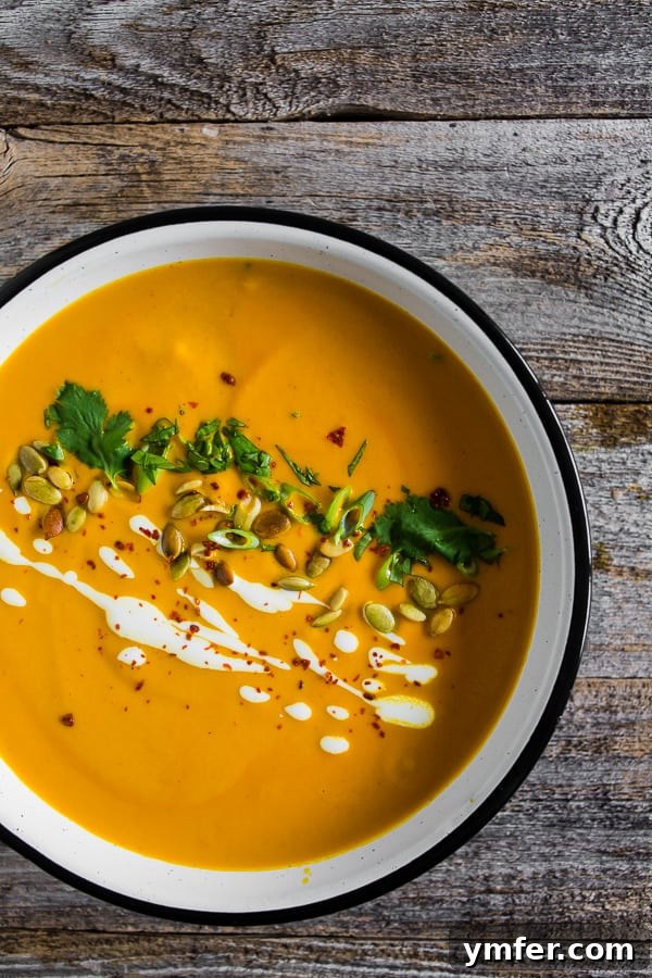 Thai Pumpkin Spice Soup 5 A close-up of Spicy Thai Pumpkin Soup topped with fresh cilantro and a swirl of Greek yogurt.