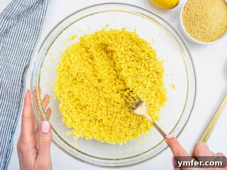 hands fluffing up couscous with a fork