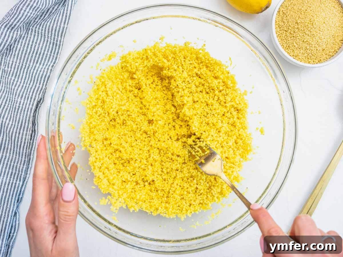 hands fluffing up couscous with a fork