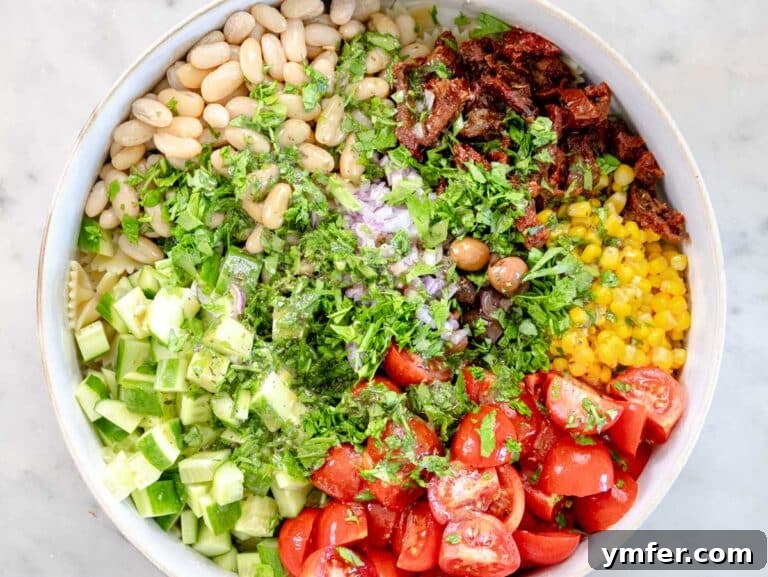 Vibrant Vegan Pasta Salad 11 Chopped vegetables and pasta in a mixing bowl.