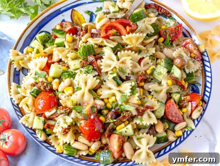 Vibrant Vegan Pasta Salad 13 Vegan Pasta Salad on a Mediterranean plate with cherry tomatoes, ready to serve.