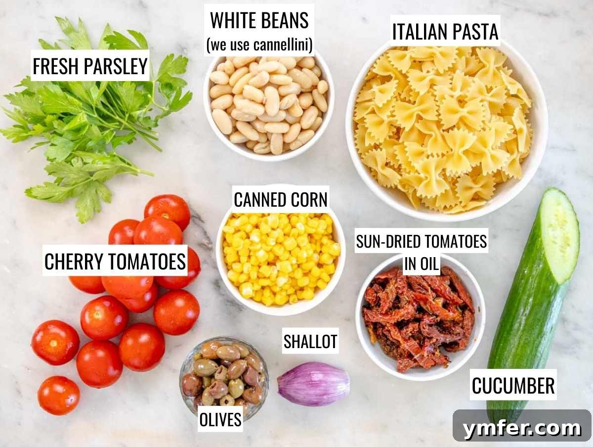 Vibrant Vegan Pasta Salad 3 INGREDIENTS FOR VEGAN PASTA SALAD ON A MARBLE TABLE, showing various fresh vegetables, pasta, and dressing components.