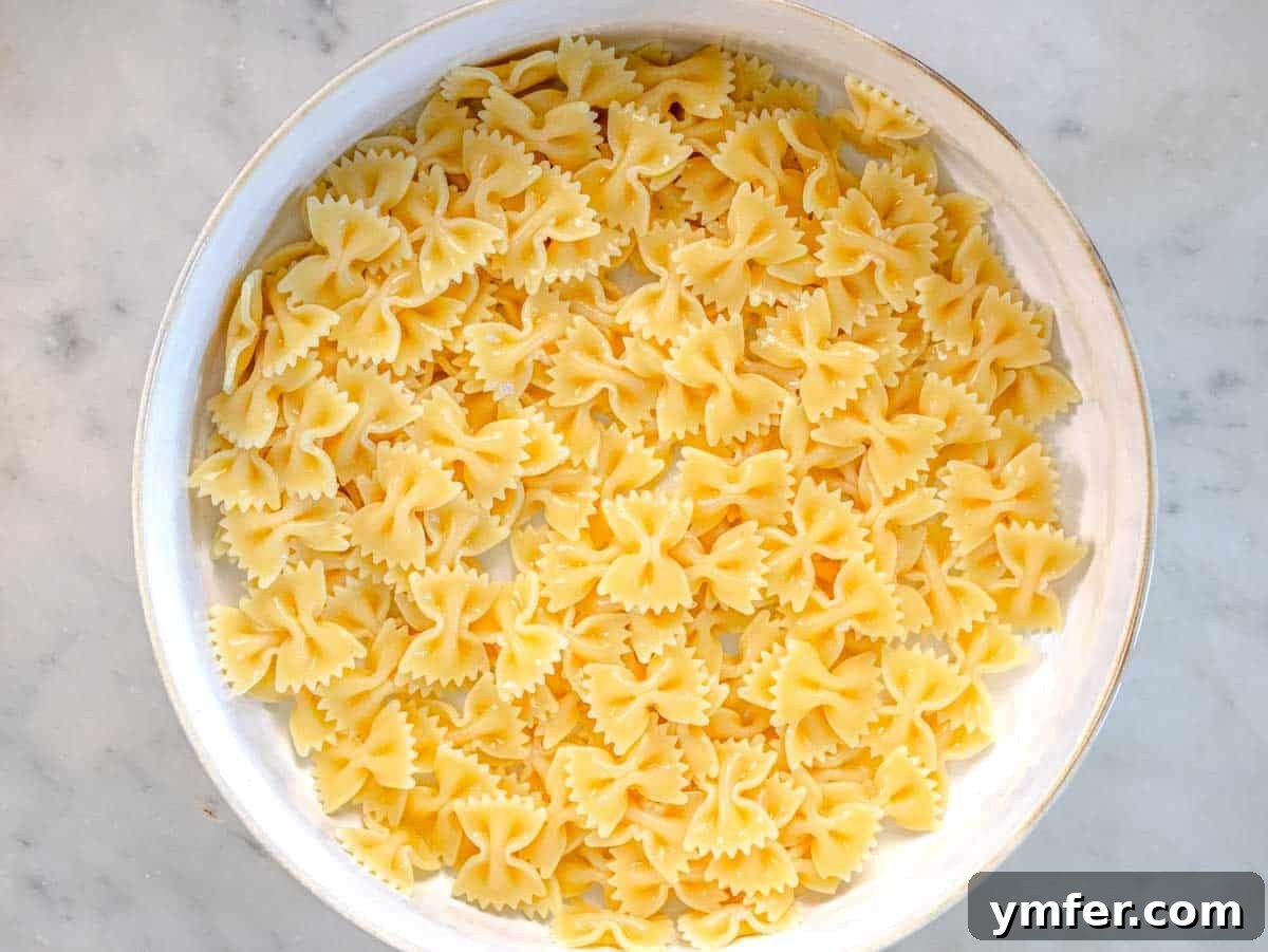 Vibrant Vegan Pasta Salad 5 Bowtie pasta in a white colander, freshly rinsed and ready.