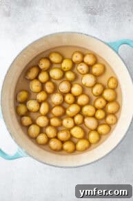 Baby potatoes boiling in heavily salted water on the stovetop.