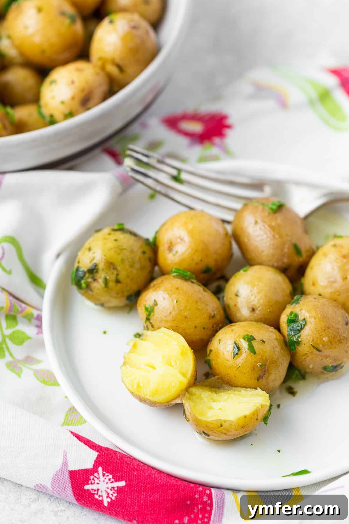 Syracuse Salt Potatoes on a small plate, one cut in half to show the creamy interior.