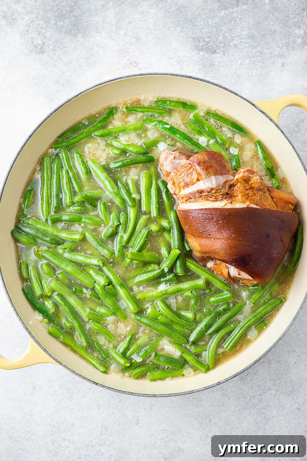 Down-Home Southern Green Beans and Potatoes 4 Green beans in a pot with a ham hock and stock.