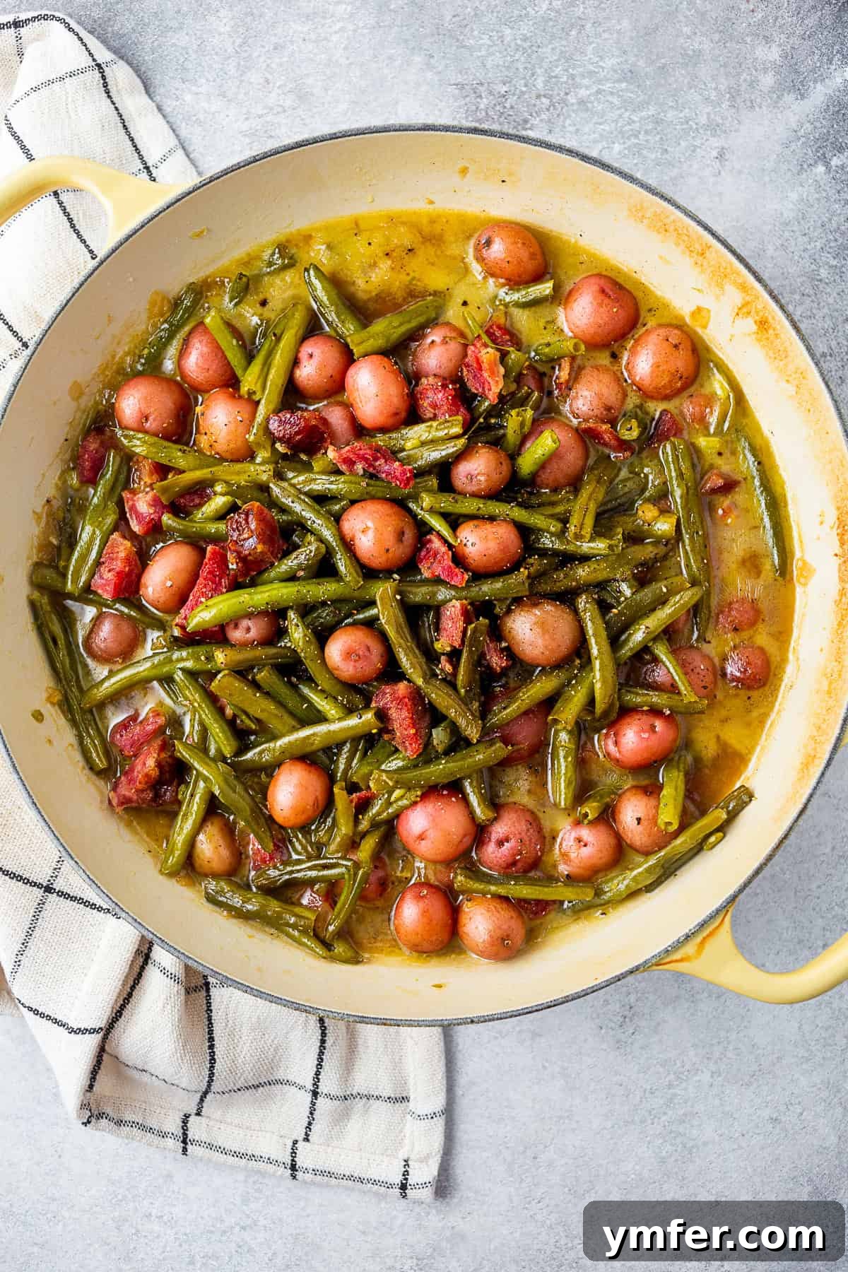 Down-Home Southern Green Beans and Potatoes 5 Green beans, potatoes, and ham in a large round skillet.