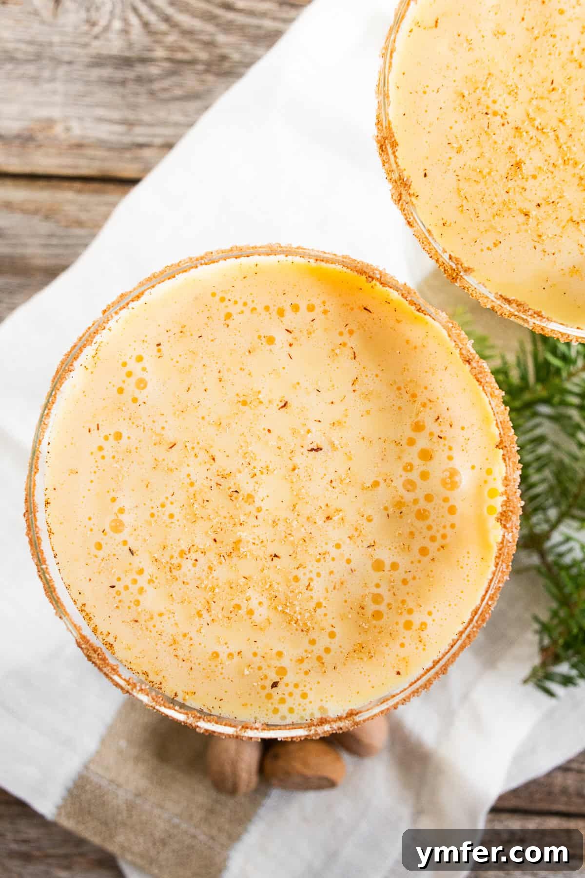 Holiday Cheer Martini 4 Close-up of an Eggnog Martini in a glass with a cinnamon sugar rim, topped with grated nutmeg, ready to be enjoyed.
