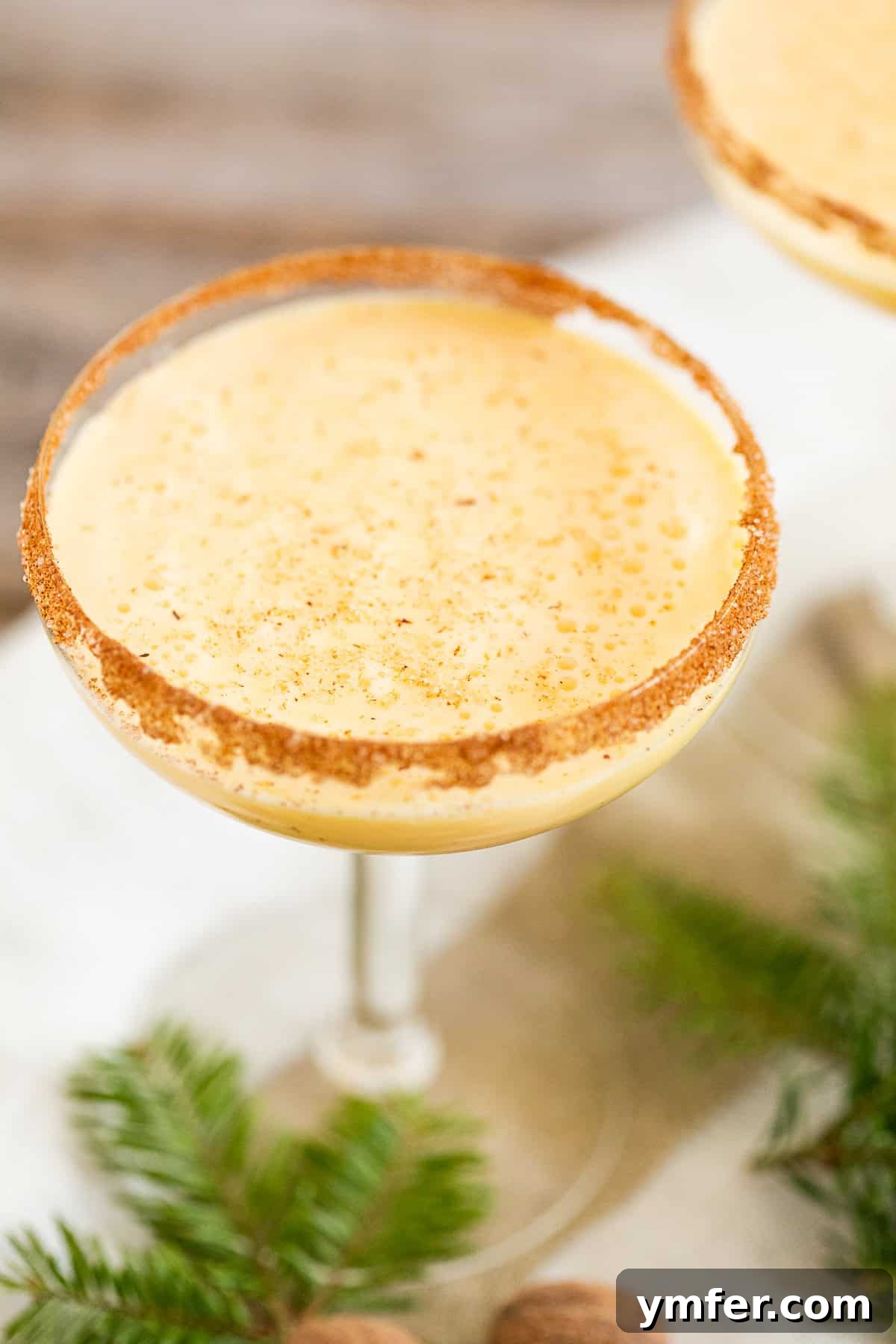 Holiday Cheer Martini 6 Two elegant Eggnog Martinis with a cinnamon sugar rim, topped with grated nutmeg, presented beautifully on a festive surface.