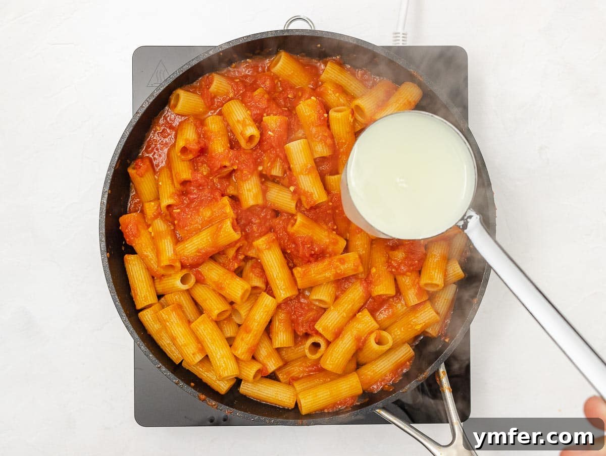 Fiery Rigatoni 10 drained rigatoni pasta added to the arrabbiata sauce in a pan