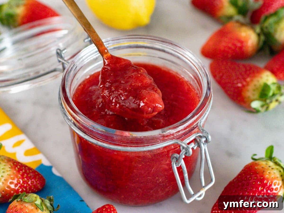 Summer in a Jar 4 A freshly prepared jar of homemade strawberry jam, highlighting its vibrant color and smooth texture.