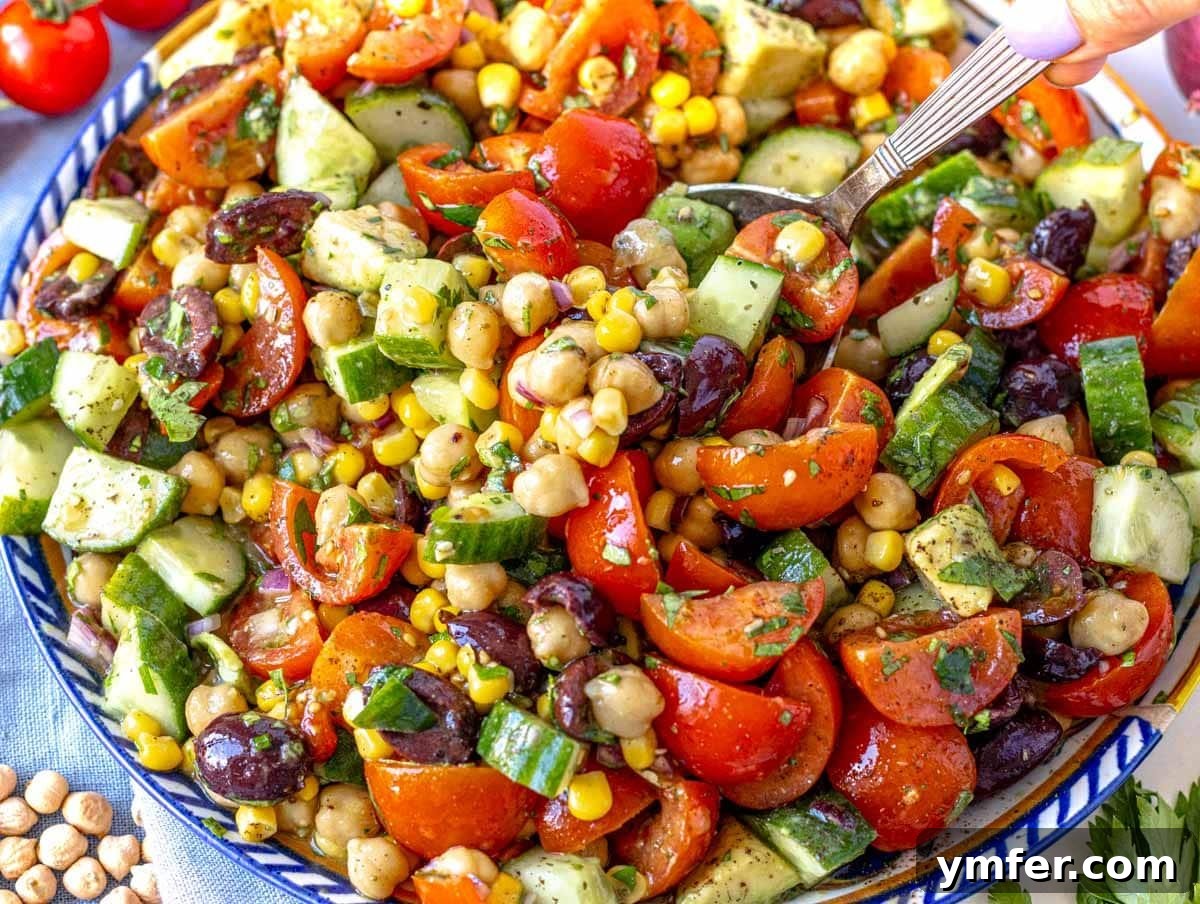 Feast on Plants: 35 Vibrant Recipes 11 Chickpea salad served on a plate with fresh cucumber and cherry tomatoes.